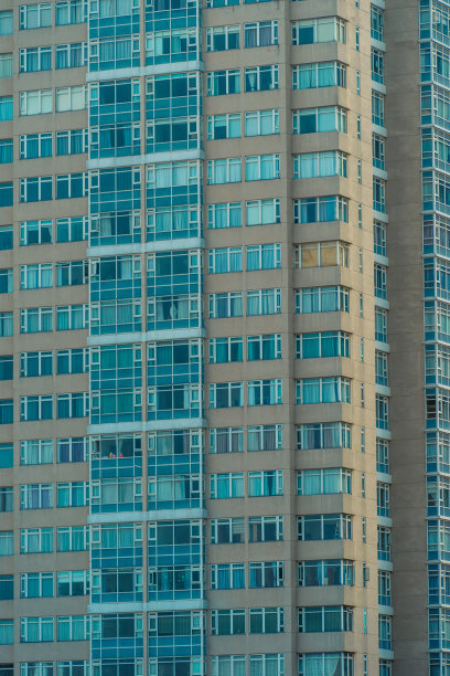 现代城市高层建筑的玻璃幕墙，展示了白天人类活动使用的照明，能源的使用。白天摩天大楼的窗户闪闪发光。图片下载