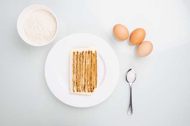 烘烤蛋糕的原料(鸡蛋、面粉、糖)放在白色的桌子上。自制的面包店的概念图片下载