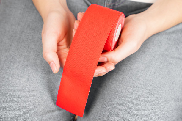 手里拿着肌内素胶带的女人。运动学，物理治疗，康复概念图片下载