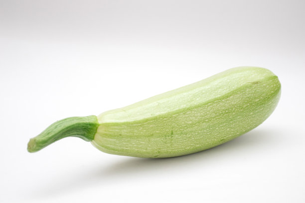 一个绿色西葫芦在白色的背景图片下载
