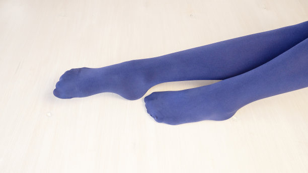 一个穿着蓝色紧身裤的漂亮年轻女孩的腿。图片下载