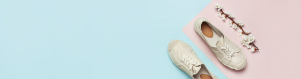 米色时尚女性帆布鞋与春天开花分支的颜色柔和的蓝色粉红色的背景。创意概念的春季鞋，时尚博客或杂志的概念平铺俯视拷贝空间图片下载