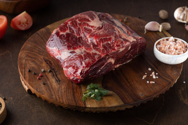 生鲜肉肋眼牛排，调味料和新鲜番茄在木制背景图片下载