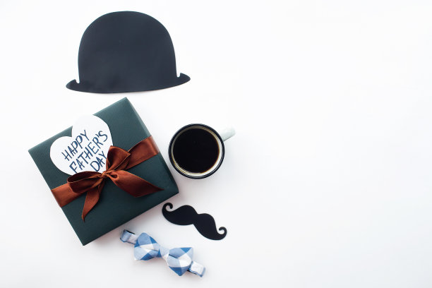 父亲节的节日概念。扁平帽，咖啡杯，礼物和一个有趣的黑色胡子上孤立的白色背景。为铭文复制空间。图片下载