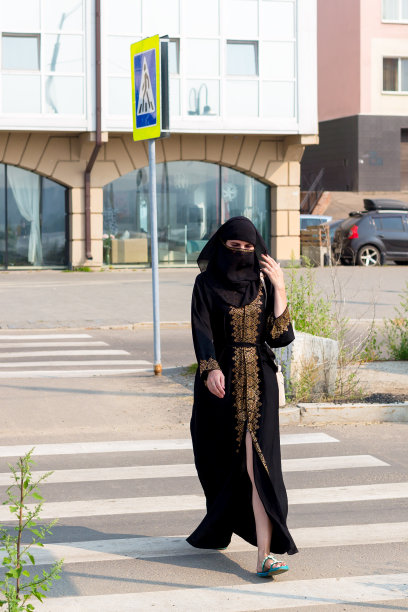 穿着民族服装的穆斯林妇女走在人行横道上赶往商店图片下载