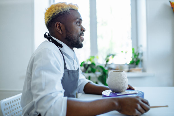 积极的拉丁西班牙裔巴西人的肖像在陶轮上制作陶瓷壶图片下载