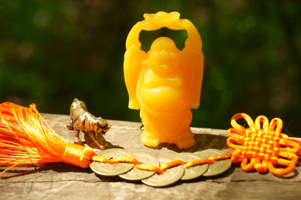一尊佛像，一串中国钱币，还有一只金属老虎。一个深奥的象征。图片下载