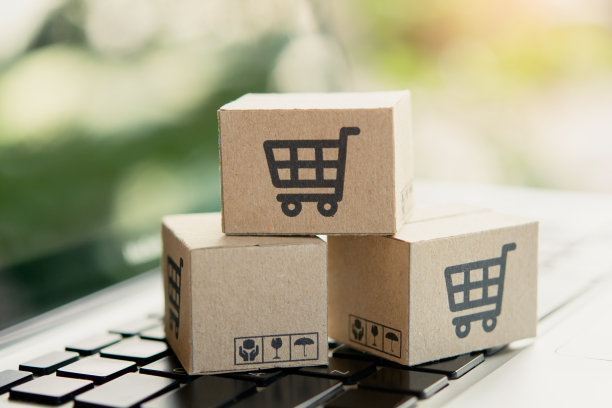 网上购物。笔记本电脑键盘上带有购物车标志的纸板箱。网上购物服务。提供送货上门。本空间图片下载