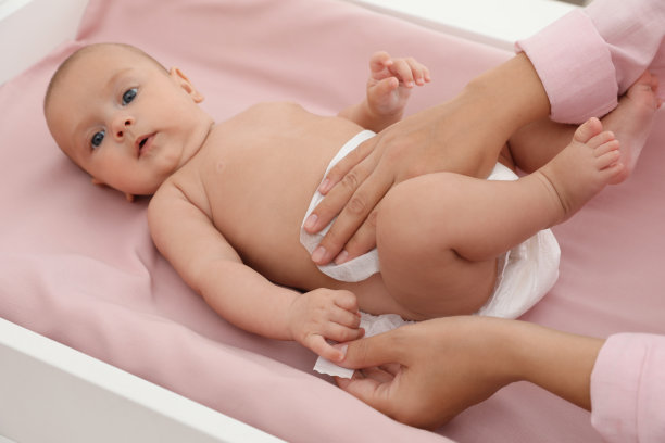 妈妈在桌子上给孩子换尿布图片下载