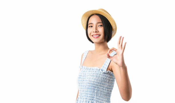 幸福的亚洲女人的肖像显示ok标志，并看着相机在白色背景。图片下载
