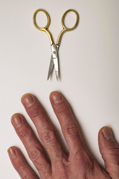 一个男人的手，白色的背景上长着粗大的指甲和剪刀图片下载