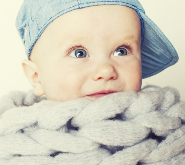 小可爱红头发的宝宝围在围巾上把他围得孤立无援，可爱的孩子冬天概念冷图片下载