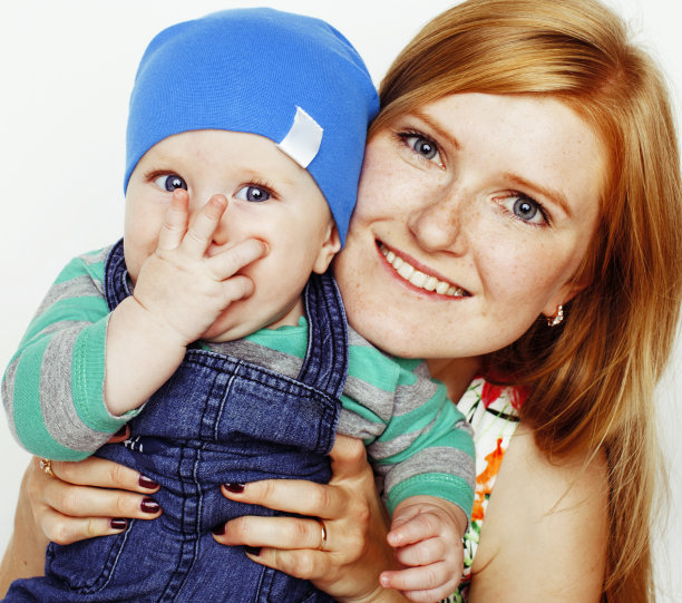 年轻美丽的母亲带着可爱的宝宝，红发快乐的现代家庭微笑孤立在白色背景上的特写，生活方式的人的概念图片下载
