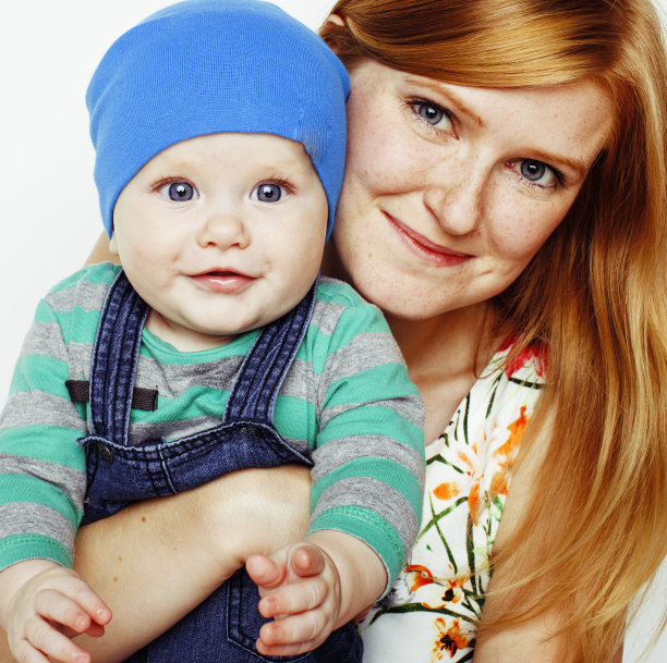 年轻美丽的母亲带着可爱的宝宝，红发快乐的现代家庭微笑孤立在白色背景上的特写，生活方式的人的概念图片下载