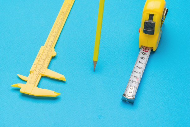 黄色铅笔，卡尺和卷尺，蓝色背景。图片下载