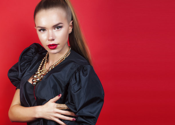 年轻漂亮的女人在红色背景上摆姿势，生活方式的人的概念图片下载