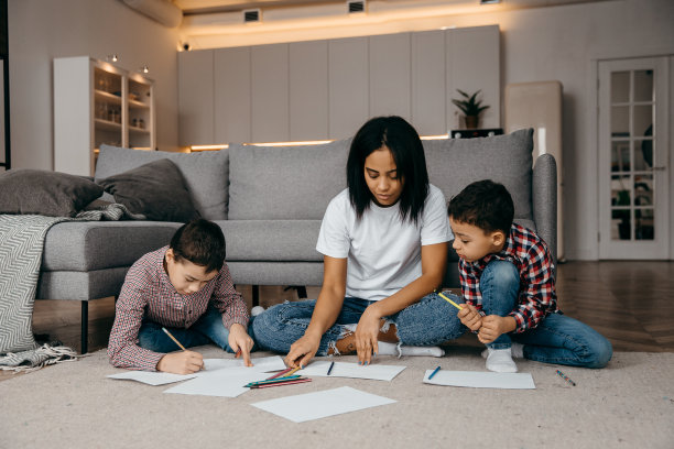 快乐的非裔美国母亲在教她的儿子们用铅笔画画图片下载