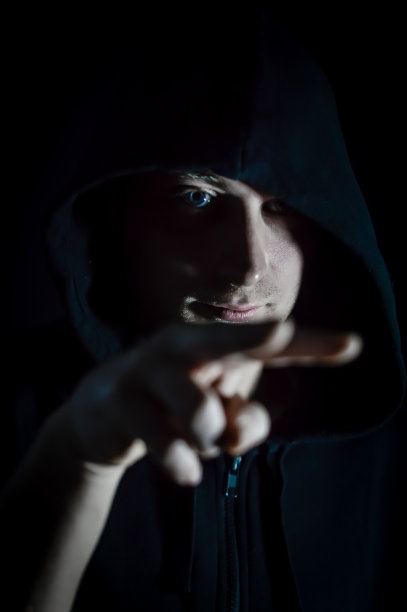 我在看着你——年轻的蒙面男子向一个人做了一个两根手指的手势，表示他在看着她图片下载