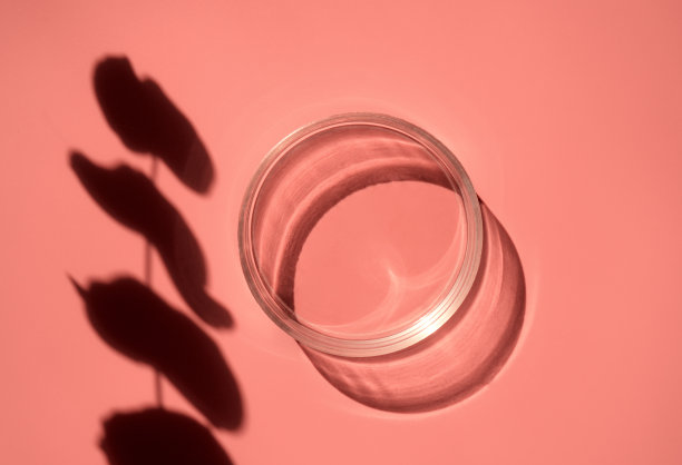 空的实验室玻璃培养液，血清，油，美容产品在粉红色的橙色背景与阴影。天然药物图片下载