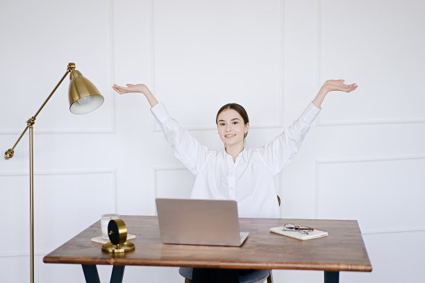 一个年轻的女人在他的电脑显示器上得到了好消息图片下载