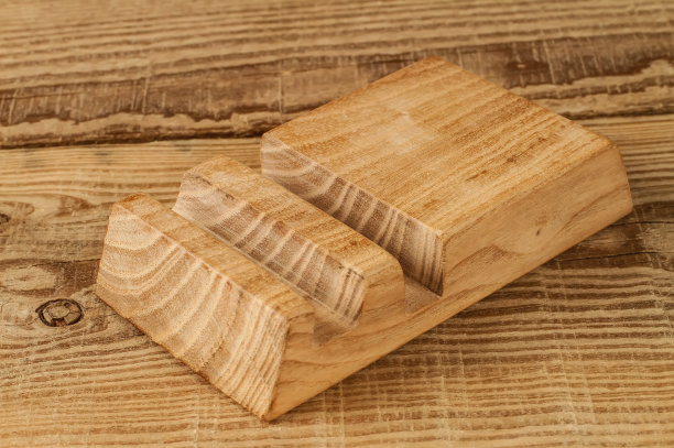 木头背景上的木制智能手机支架。图片下载