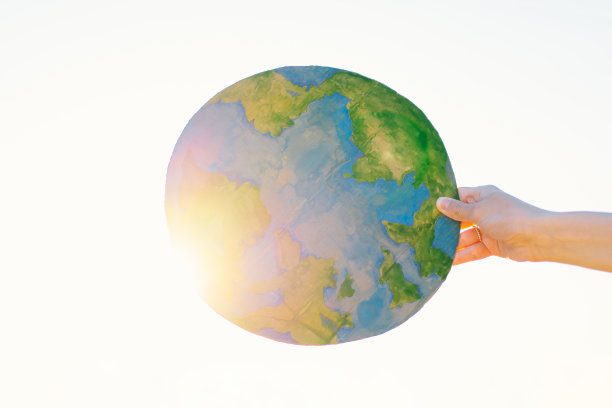 女人手里拿着行星，背景是绿色的春天图片下载