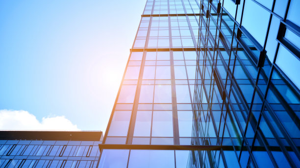 玻璃幕墙的现代办公大楼，背景是晴朗的天空。图片下载