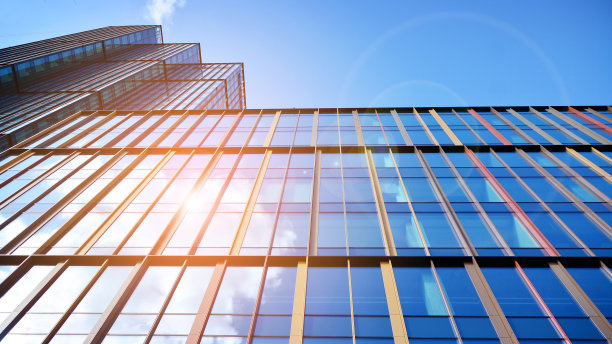 玻璃幕墙的现代办公大楼，背景是晴朗的天空。图片下载