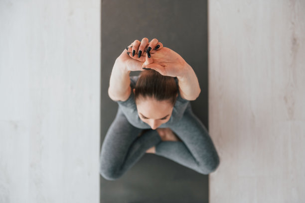 坐在地板上。身材苗条、穿着瑜伽服的年轻女子在家里图片下载