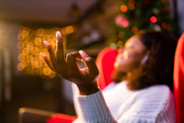 安详的年轻女子闭上眼睛放松倚靠在沙发上现代无线耳机在耳塞图片下载