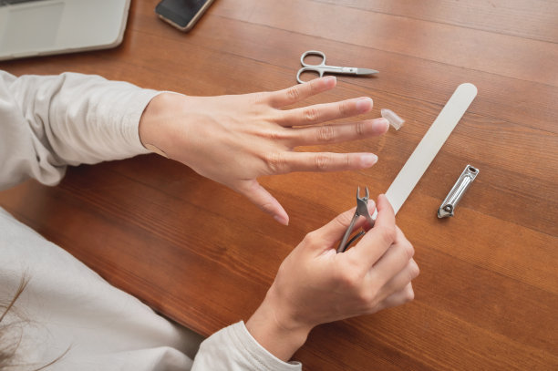 特写的手白人年轻女子做美甲在家里与指甲供应。图片下载