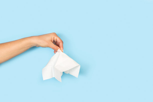 淡蓝色背景上拿着纸巾的女人的手图片下载