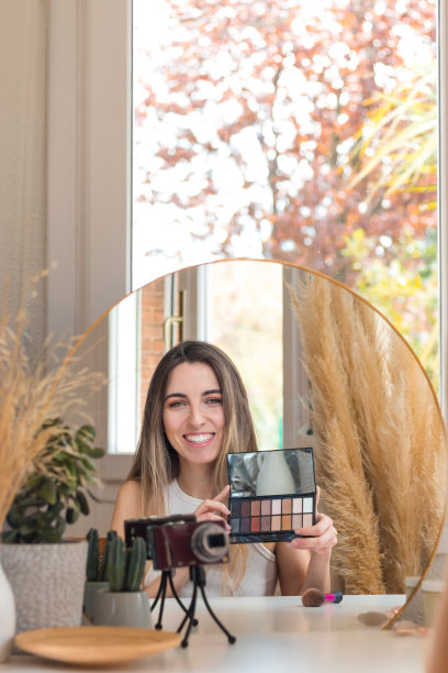 年轻微笑的女人在网上展示新的美容产品看着相机图片下载