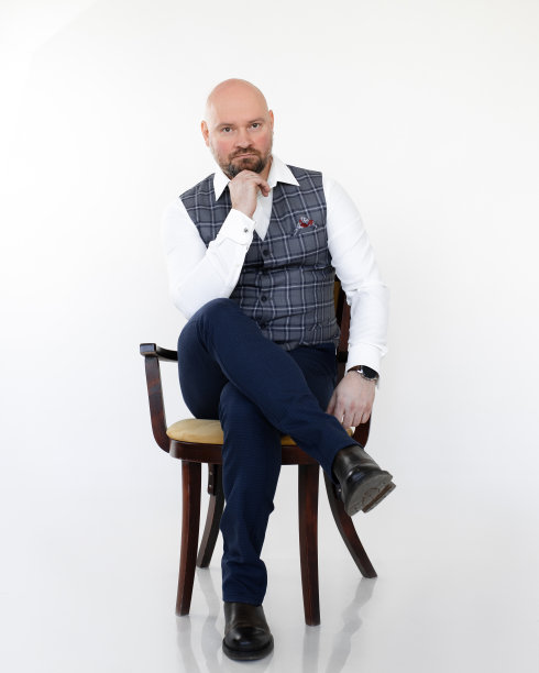 深思熟虑的中年商人肖像，穿着灰色背心，蓝色牛仔裤，白色衬衫坐着，把头靠在下巴上。图片下载