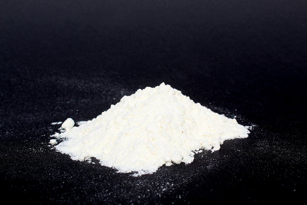 一堆白面粉放在黑色的背景上。图片下载