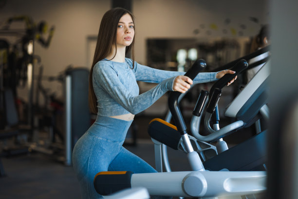 健身女孩在健身房椭圆轨道锻炼图片下载