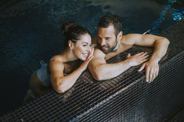 一对年轻夫妇在游泳池里放松图片下载