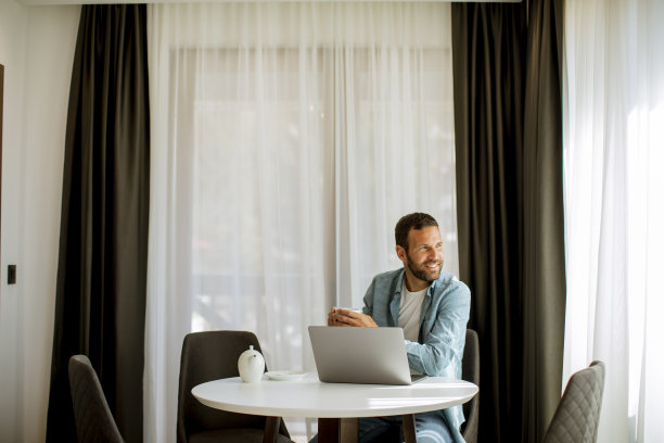 年轻人在客厅里用笔记本电脑喝茶图片下载