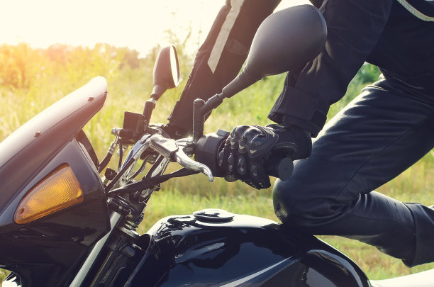 女人坐在摩托车在太阳耀光的大气背景下，时髦的摩托车手女性手臂和腿的close up，摩托车街道生活方式，旅行者计划自行车路线在夏天图片下载