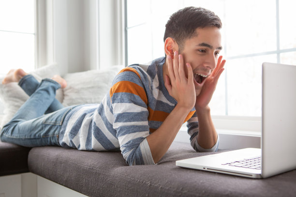 惊讶的年轻人使用笔记本电脑图片下载