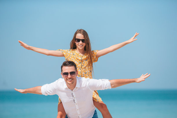 小女孩和快乐的爸爸在海滩度假图片下载