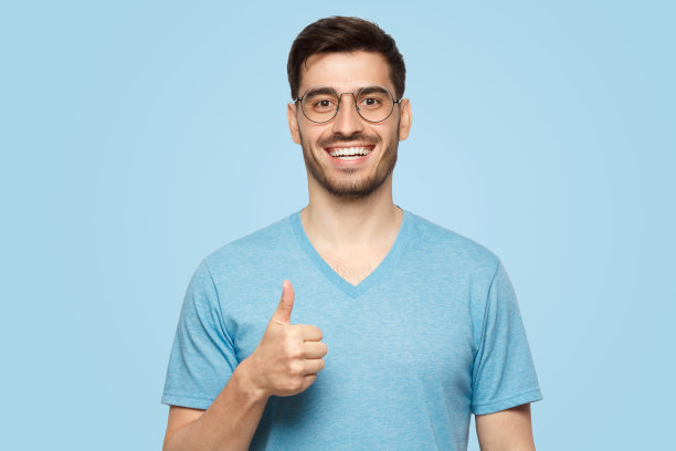 穿着蓝色t恤的年轻人竖起大拇指图片下载