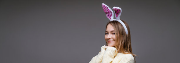 灰色背景上戴兔耳朵的年轻女子图片下载