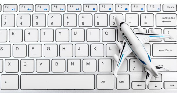 电脑键盘上的飞机玩具。在网上订购门票。在线查看飞机状态。图片下载