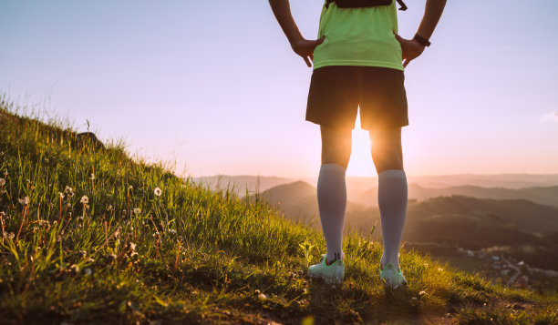 活跃的山地步道跑步者穿着明亮的t恤与背包享受日落，而他的天空运行在风景如画的山在日落时间。运动积极的人或动机的概念图片下载