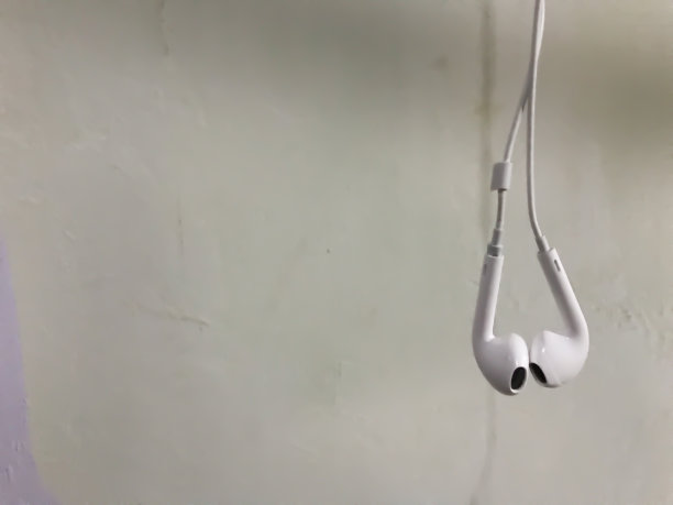 白色耳机隔离在白色背景与复制空间背景。白色现代耳机与耳机在浅灰色的背景。数字音乐的概念图片下载