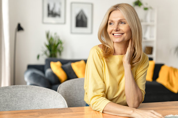迷人的无忧无虑的中年妇女坐在沙发上放松。迷人的成熟女人白日做梦的水平镜头图片下载
