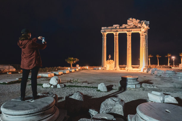 土耳其安塔利亚，晚上阿波罗神庙边的女游客拍照图片下载