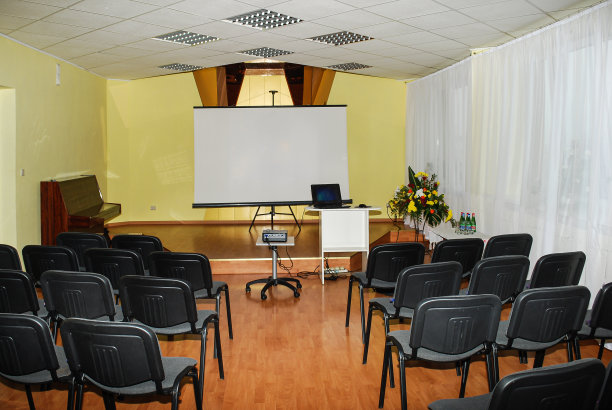 会议室配有投影仪、屏幕、笔记本电脑、椅子、鲜花和钢琴。图片下载