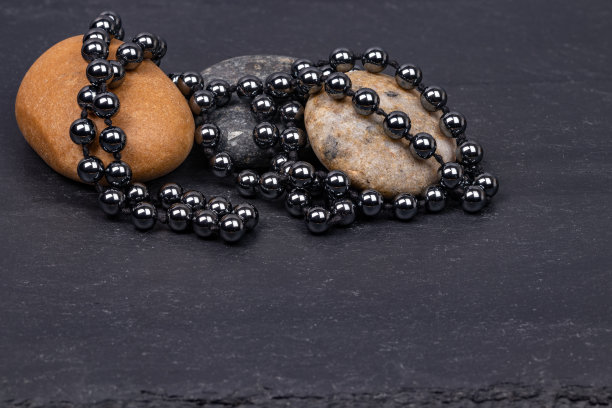 粗糙的花岗岩上的黑色珍珠项链图片下载